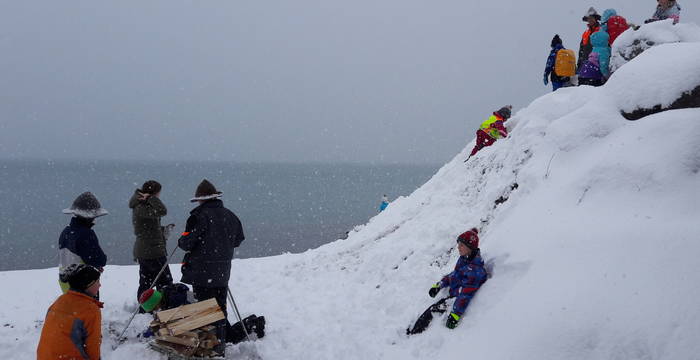 Kinder rutschen einen Schneehang hinunter
